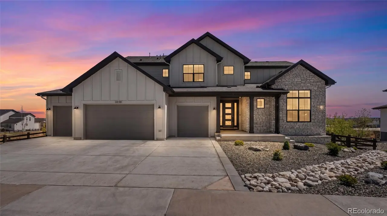 Modern farmhouse exterior at twilight with stone accents in Castle Rock