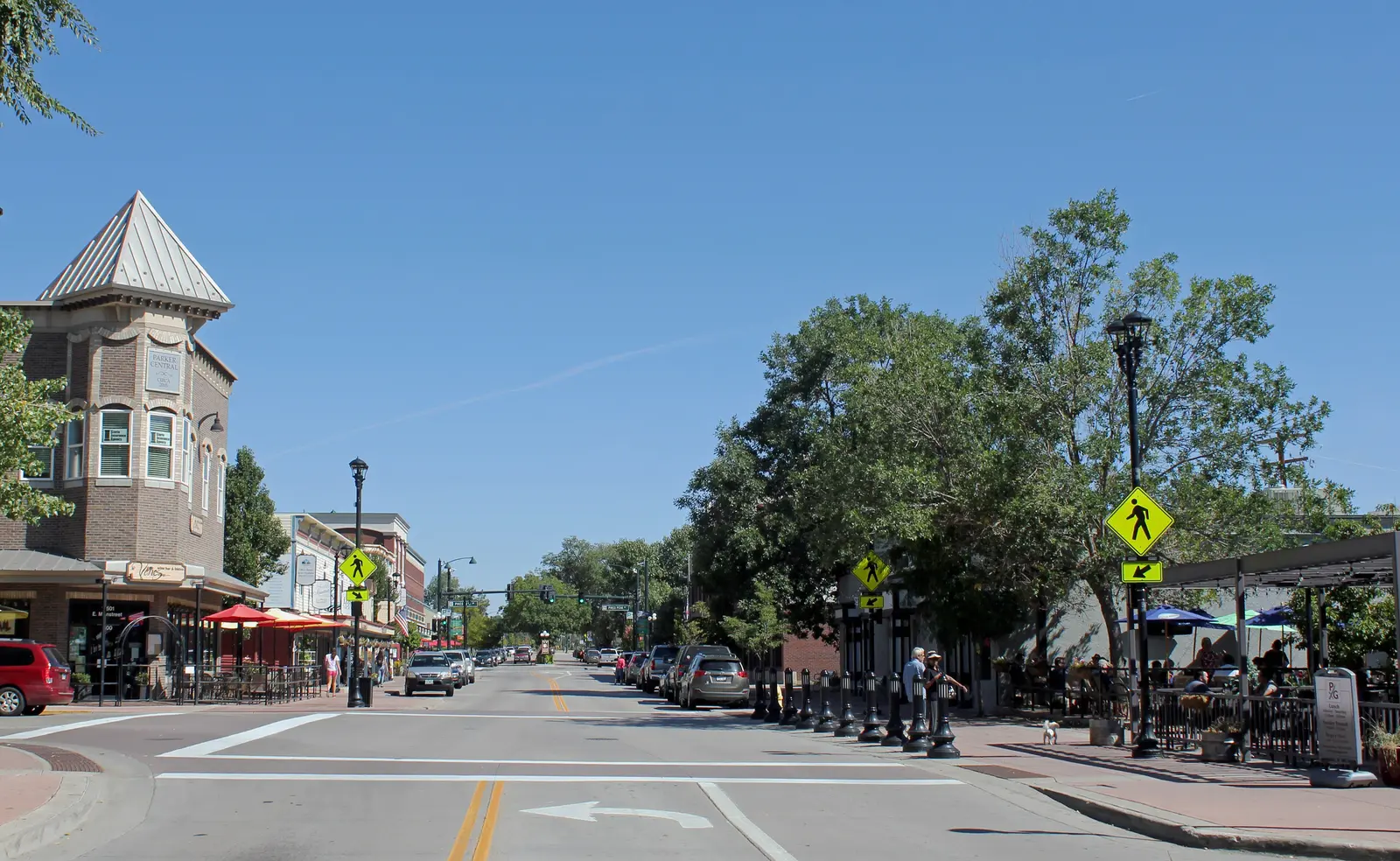 Mainstreet in downtown Parker, Colorado, with brick storefronts, street trees, and outdoor café seating