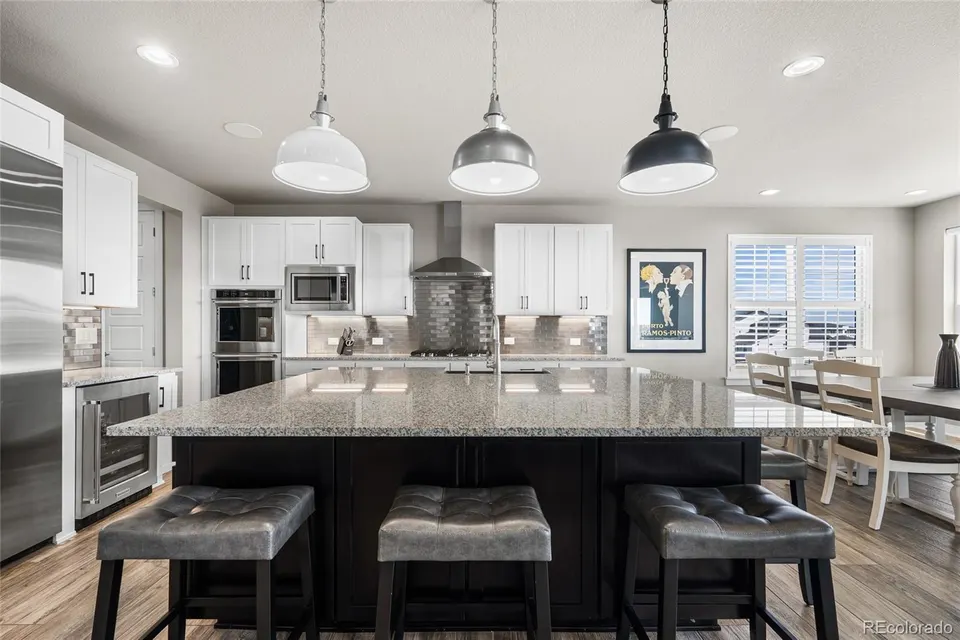 Kitchen island seating with granite counters and double ovens