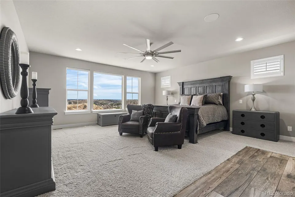 Primary bedroom with sitting area and large windows