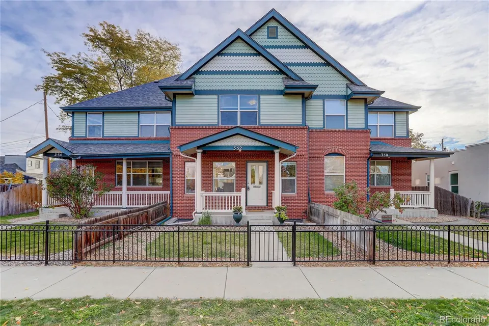 Red brick and painted-gable Victorian duplex at 352 Galapago Street in the Baker Historic District