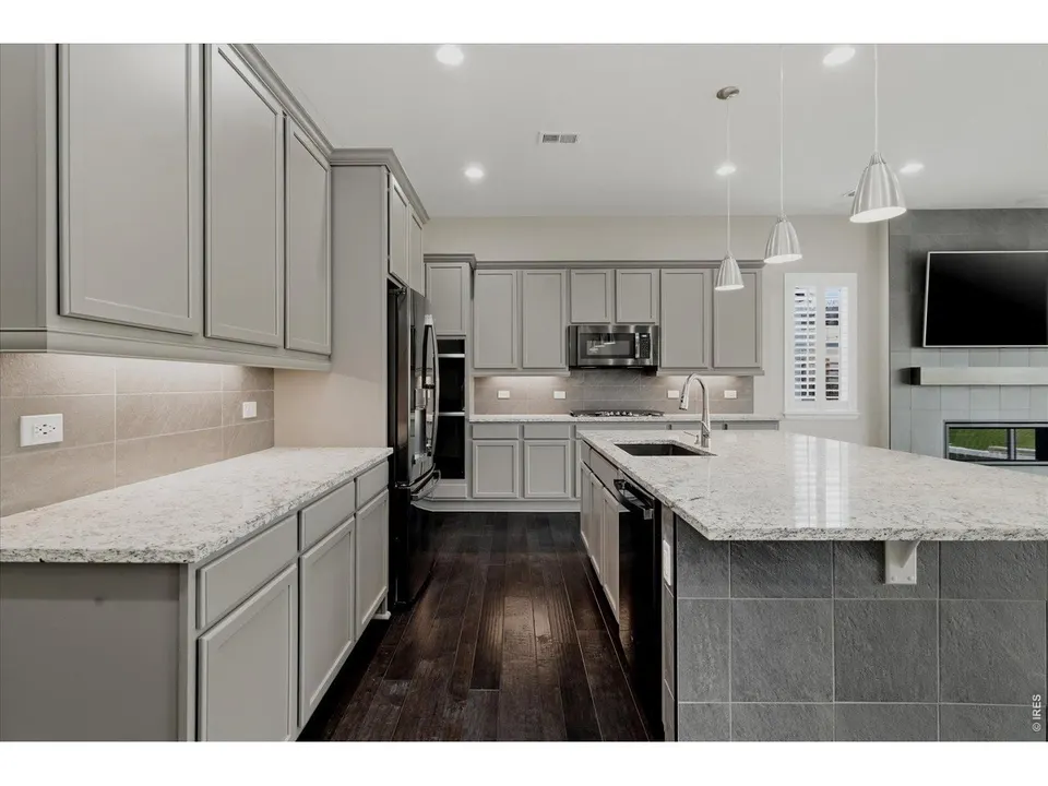 Kitchen with gray cabinetry and pendant lighting