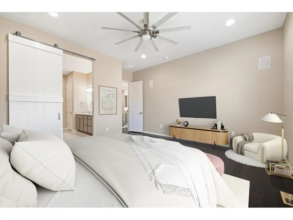 Main-floor primary bedroom with barn door to bath